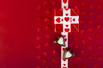 Image showing Gift and chocolate and red hearts on red