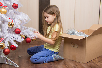 Image showing Sad girl removes a Christmas tree with toys