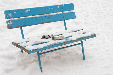 Image showing On a snow-covered bench lie forgotten childrens mittens