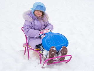 Image showing Joyful girl sitting on a sled