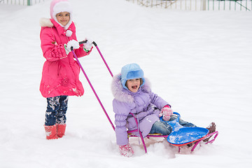 Image showing Two girls ride each other on a sled