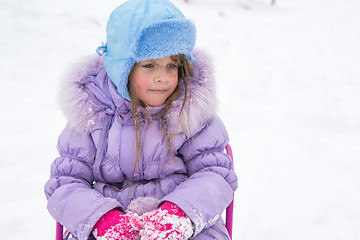 Image showing Tired girl sitting on a sled