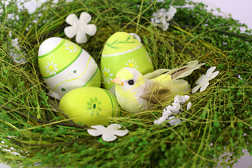 Image showing green nest with small toy bird and eastereggs