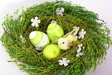 Image showing green nest with small toy bird and eastereggs