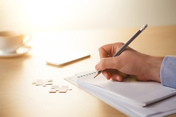 Image showing The male hands with a pencil and the cup