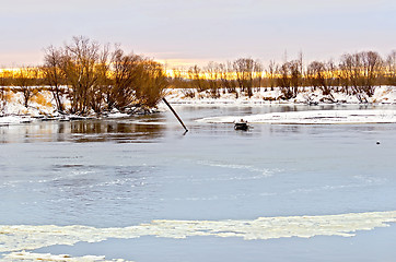 Image showing River with ice and snow-covered beach with trees