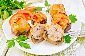 Image showing Champignons stuffed meat cut in white plate on light board