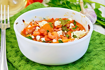 Image showing Shrimp and tomatoes with feta in white bowl on board