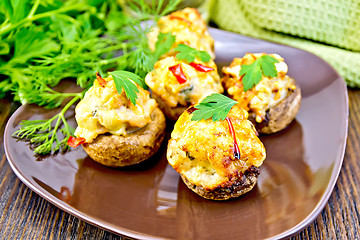 Image showing Champignons stuffed meat in brown plate on dark board