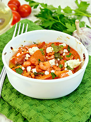 Image showing Shrimp and tomatoes with feta in white bowl on green napkin