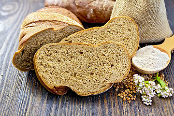 Image showing Bread buckwheat with cereals and flower on dark board