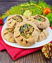 Image showing Carols in dish with mushrooms and Christmas decorations on board