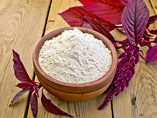 Image showing Flour amaranth in clay bowl on board with flower