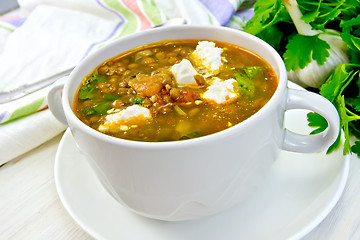 Image showing Soup lentil with spinach and feta in white cup on board