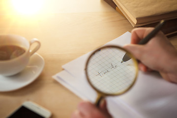 Image showing The male hands with a pencil and magnifying glass