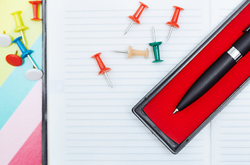 Image showing Notepad with pen and pushpins