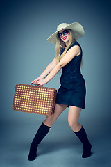 Image showing The traveler woman standing with retro suitcase 