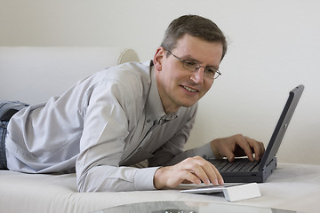 Image showing Man on coach with laptop computer