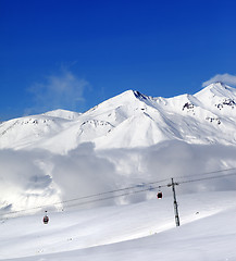 Image showing Winter snowy mountains and cable car at nice day