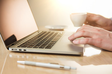 Image showing The hand on the keyboard and coffee