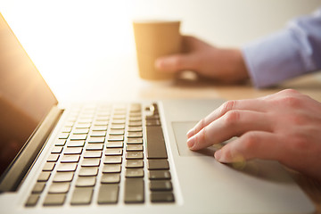 Image showing The hand on the keyboard and coffee