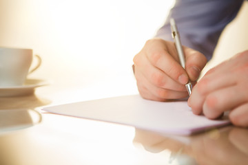 Image showing The male hand with a pen and the cup