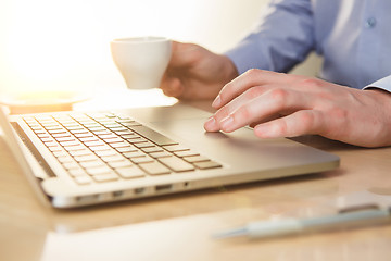 Image showing The hand on the keyboard and coffee