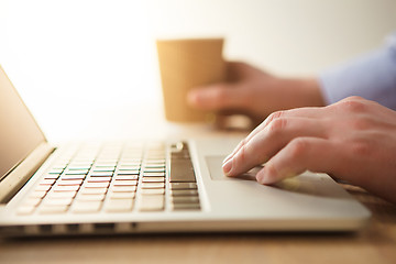 Image showing The hand on the keyboard and coffee