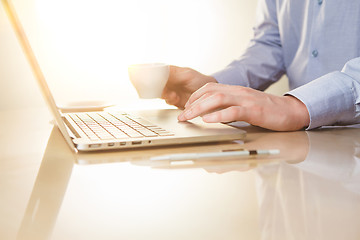 Image showing The hand on the keyboard and coffee