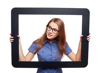 Image showing Surprised female peeping out of tablet frame