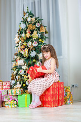 Image showing Happy little girl with christmas present smiling