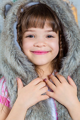 Image showing Cute little happy girl posing in a fur hat.