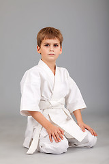 Image showing Karate boy in white kimono is sitting