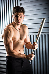 Image showing muscular man posing with a bat