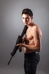 Image showing Handsome bare-chested soldier is holding a rifle