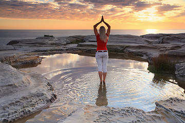 Image showing Woman yoga meditation by the ocean sunrise