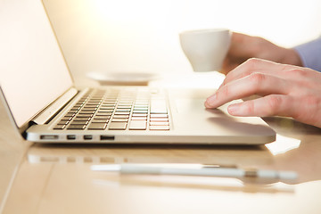 Image showing The hand on the keyboard and coffee