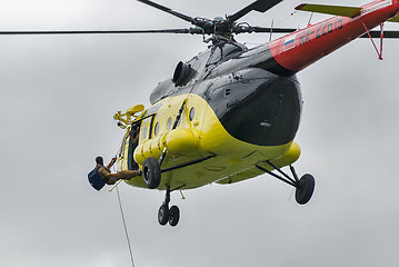 Image showing Rescuer is landed from MI-8 helicopter by rope