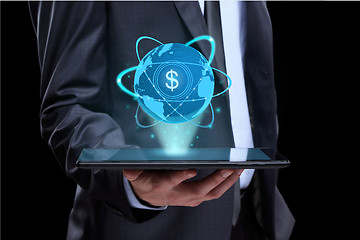 Image showing Businessman holding tablet with a projected on-screen icon online trading dollar. business Internet concept.