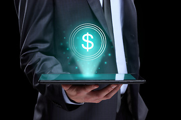 Image showing Businessman holding tablet with a projected on-screen icon online trading dollar. business Internet concept.