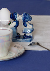 Image showing Pretty porcelain figurine on a table laid for an early breakfast