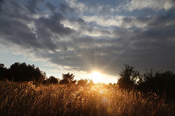 Image showing sunset with clouds over field