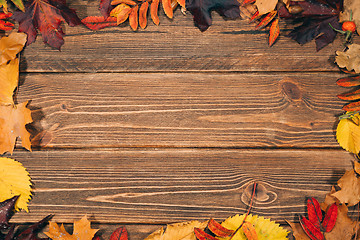 Image showing Background with wooden table and autumnal leaves