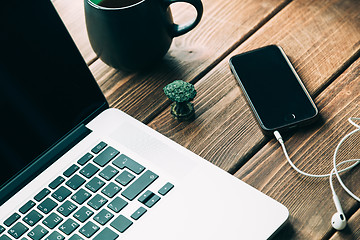 Image showing Workplace with open laptop on modern wooden desk 