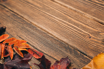 Image showing Background with wooden table and autumnal leaves
