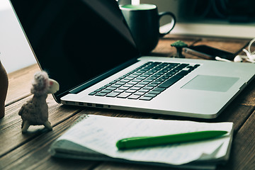 Image showing Workplace with open laptop on modern wooden desk 