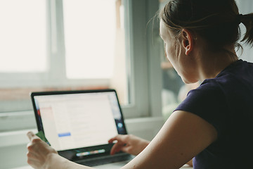 Image showing Woman working with laptop placed on wooden desk