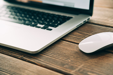 Image showing Workplace with open laptop on modern wooden desk 