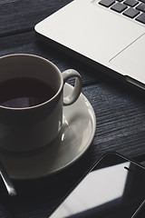 Image showing Office table with notepad, computer and tea cup