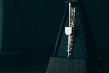 Image showing Vintage metronome, on a dark background.